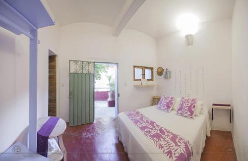 - une chambre avec un lit et une porte coulissante en verre dans l'établissement Boca del Monte by Diablo y la Sandia B&B, à Oaxaca