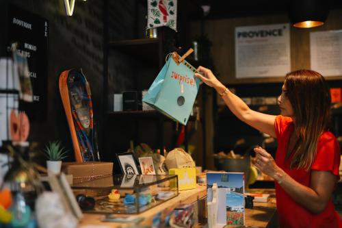 a woman is holding an umbrella in a store at ibis Aix en Provence in Aix-en-Provence