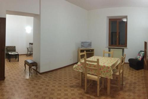 ein Wohnzimmer mit einem Tisch und Stühlen sowie ein Zimmer mit einem Tisch in der Unterkunft Villa Roma in Alfedena