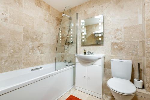 un bagno con un water, un lavandino e una vasca di Kidwelly Farm Cottage a Kidwelly