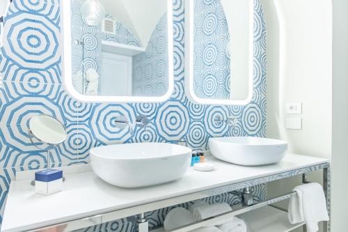 een badkamer met 2 wastafels en een grote spiegel bij Hotel Club Due Torri in Maiori