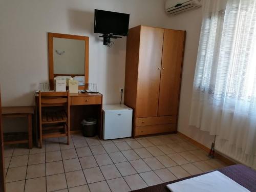 a room with a desk and a cabinet and a table at Vanta Hotel in Limenas