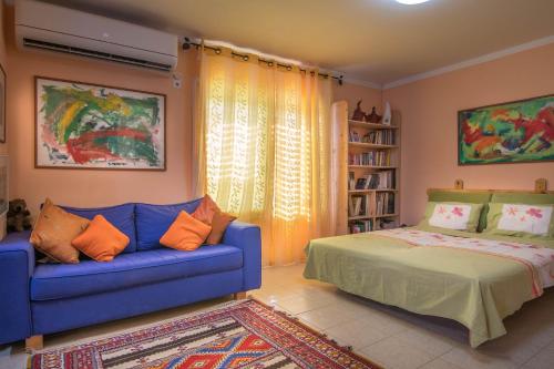 a living room with a blue couch and a bed at Or Gani in Arad