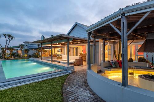 a home with a swimming pool and a house at The Sugar Shack in Ballito