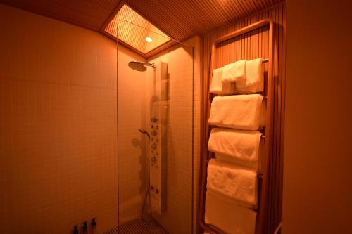 a bathroom with a walk in shower and towels at Yado Kiramachi in Kyoto