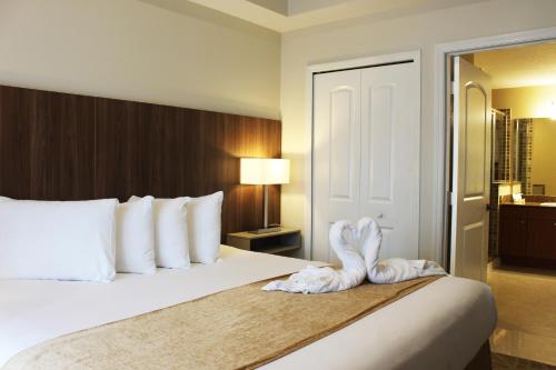 a hotel room with a bed with a towel on it at The Point Hotel & Suites Universal in Orlando