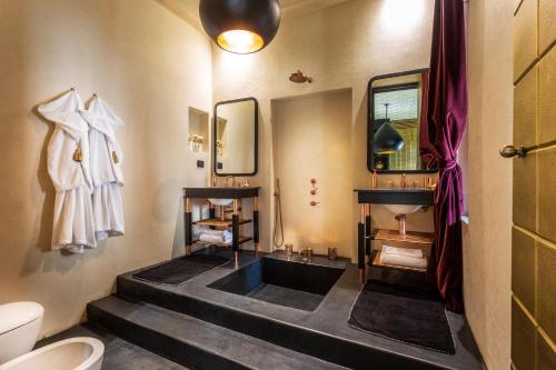 a bathroom with a sink and a toilet and a mirror at Riad Tajania in Marrakech