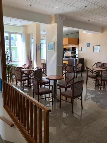 a restaurant with tables and chairs and a kitchen at Hotel International in Senigallia