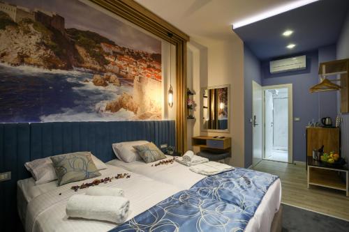 a bedroom with a bed with a large painting on the wall at Apartments and Rooms Villa Naida in Dubrovnik