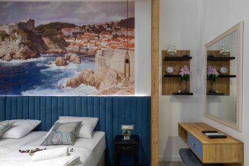 a bedroom with a bed and a painting on the wall at Apartments and Rooms Villa Naida in Dubrovnik
