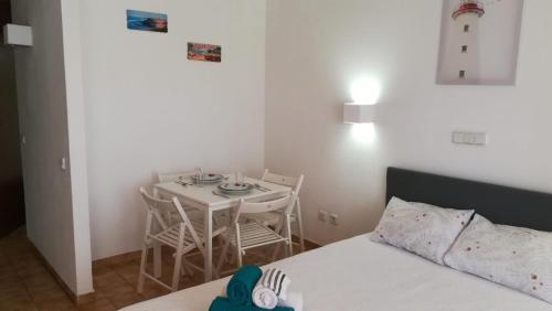 ein Schlafzimmer mit einem Tisch, einem kleinen Tisch und Stühlen in der Unterkunft Praia da Rocha Apartment 3 in Portimão