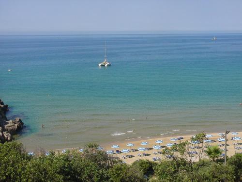 a beach with umbrellas and a boat in the water at La Maison Galu' in Itri