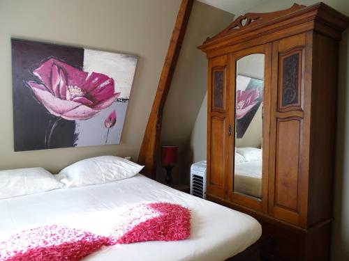 a bedroom with a bed with a dresser and a mirror at Augusta Hotel in IJmuiden