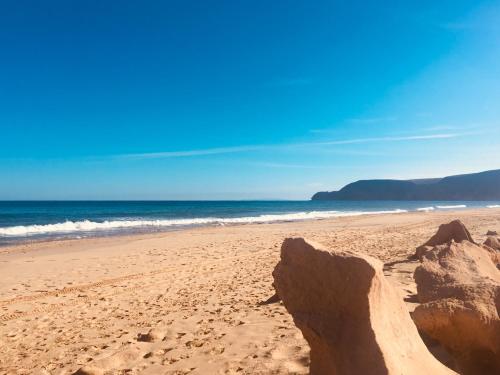 a beach with rocks in the sand and the ocean at Casinha Vista Mar in Porto Santo