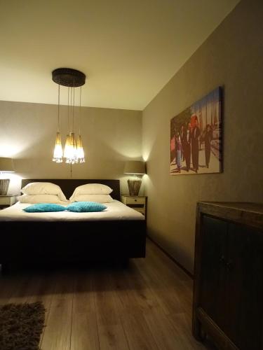 a bedroom with a bed with two blue pillows at Augusta Hotel in IJmuiden