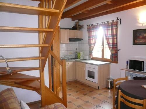 una cocina con una escalera que conduce a una pequeña cocina en A l'Ancien Moulin, en Gertwiller