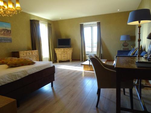 a bedroom with a bed and a desk and a desk at Augusta Hotel in IJmuiden