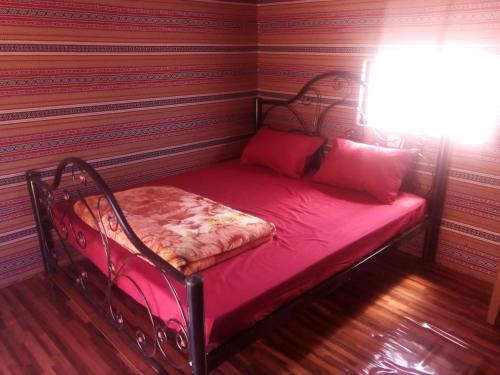 a small bed in a corner of a room at Wadi Rum Caravan Camp in Wadi Rum