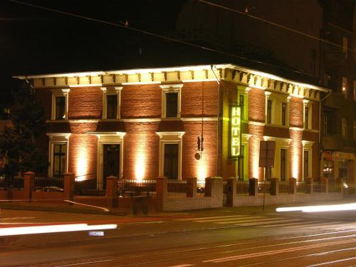 un edificio iluminado en una calle por la noche en Villa Grudziądz, en Grudziądz