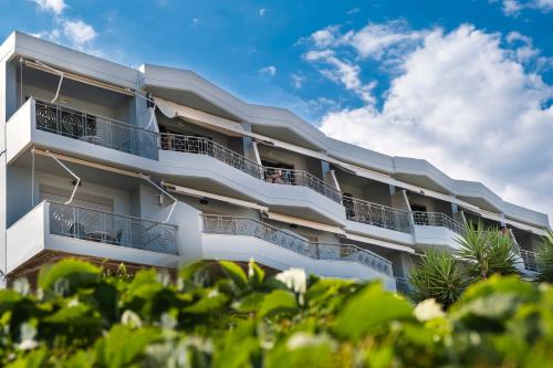 a white apartment building with balconies and trees at ELIXIA in Tolo