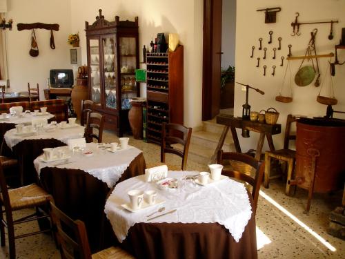 una stanza con tavoli e sedie con tovaglia bianca di Xanadu - Villa Giardinata a Valderice