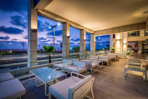a restaurant with white chairs and tables on a building at Royal Beach Hotel Tel Aviv by Isrotel Exclusive in Tel Aviv