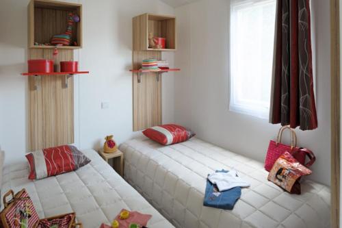 a bedroom with two beds and a window at Camping Le California in Saint-Jean-de-Monts
