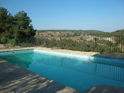 a swimming pool in a yard with a fence at La Quinta de los Enebrales in Hoyo de Pinares
