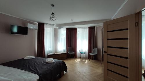 a bedroom with a bed and a room with windows at Espresso in Myrhorod