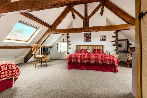 a bedroom with a red bed in a attic at Kidwelly Farmhouse in Kidwelly