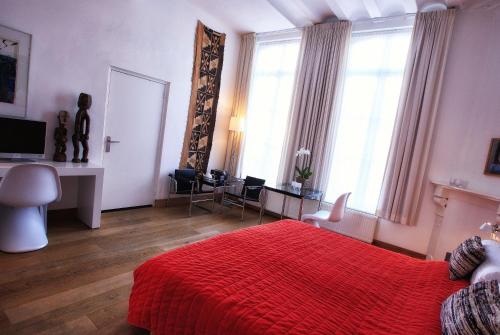 a bedroom with a red bed with a red blanket at Galerie Hotel Dis in Maastricht