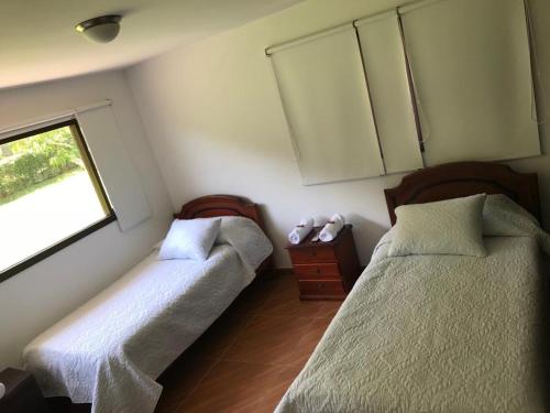two beds in a room with a window at FINCA EL RECUERDO in Gachetá