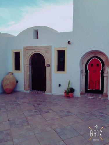 a building with two doors with a red face on it at Maison Leila chambres d hotes in Midoun