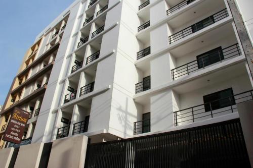 a white building with balconies on the side of it at The Atrium Ratchada 13 in Bangkok