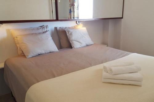 Una cama blanca con toallas encima. en 5 min walk from Yumbo! 417, en Playa del Inglés