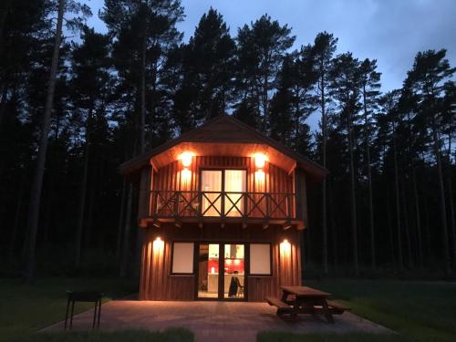 a cabin with a deck with lights on it at Brīvdienu māja VILCIŅI in Bernāti