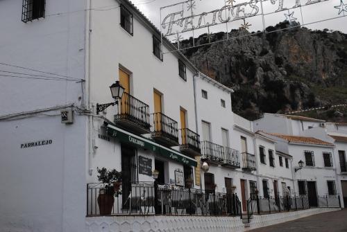 un edificio blanco con balcones en el lateral de una calle en Casa Isabel, en Zuheros
