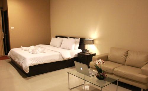 ein Hotelzimmer mit einem Bett und einem Sofa in der Unterkunft The Atrium Ratchada 13 in Bangkok