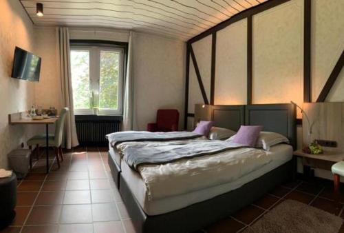 ein Schlafzimmer mit einem großen Bett und einem Fenster in der Unterkunft Burg Wassenberg in Wassenberg