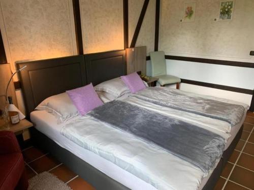a bedroom with a large bed with purple pillows at Burg Wassenberg in Wassenberg