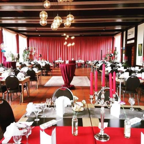 a banquet hall with tables and chairs and pink candles at Burg Wassenberg in Wassenberg