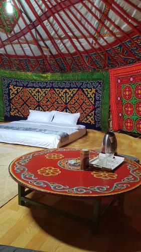 a bed and a table in a room with a bed at Ger ,Bulbul Jamak travel in Ölgiy