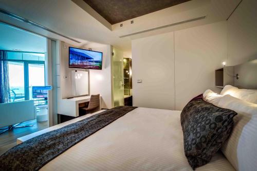 a bedroom with a large bed with a tv on the wall at Royal Beach Hotel Tel Aviv by Isrotel Exclusive in Tel Aviv