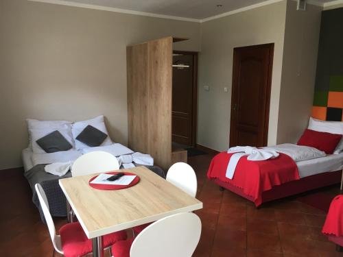 a room with a bed and a table and chairs at Apartamenty Lawenda in Rabka
