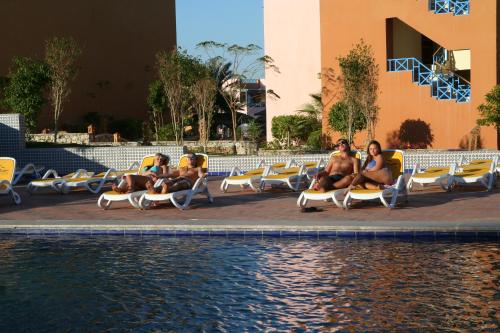 a group of people sitting on lounge chairs by a pool at Faraana Heights Aqua Park in Sharm El Sheikh