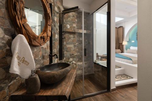 y baño con lavabo y ducha acristalada. en Casa Pietra Lindos Luxury Traditional House en Lindos
