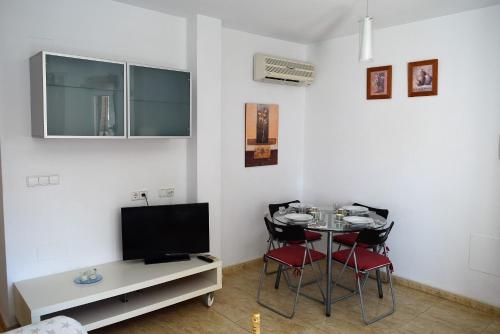 a living room with a table with chairs and a tv at Mar Menor Lo Pagan Apartment in San Pedro del Pinatar