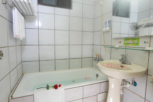a bathroom with a sink and a bath tub at King Town Hotel in Luodong