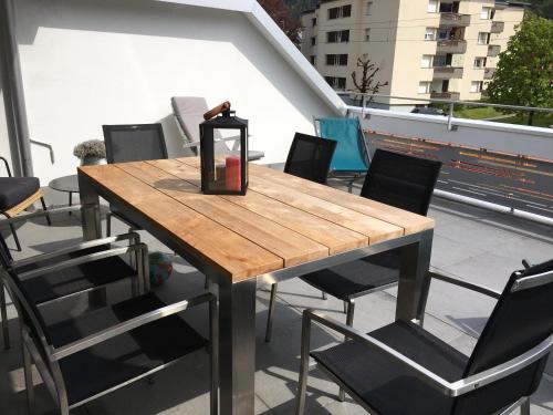 a wooden table and chairs on a balcony at Nice Apartment private host Engelberg in Engelberg