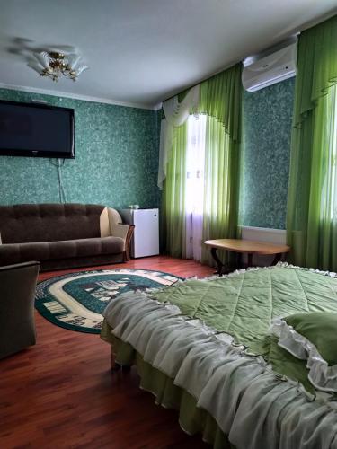 a bedroom with a bed and a couch and a tv at Hotel Tropicana in Svitlovodsʼk